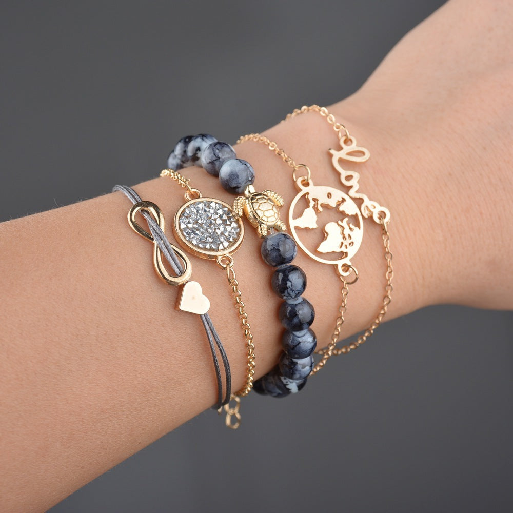 Close-up of a wrist wearing multiple gold and blue beaded bracelets on a dark background
