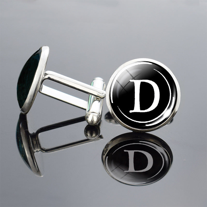 Cufflinks with a black round design featuring the letter &