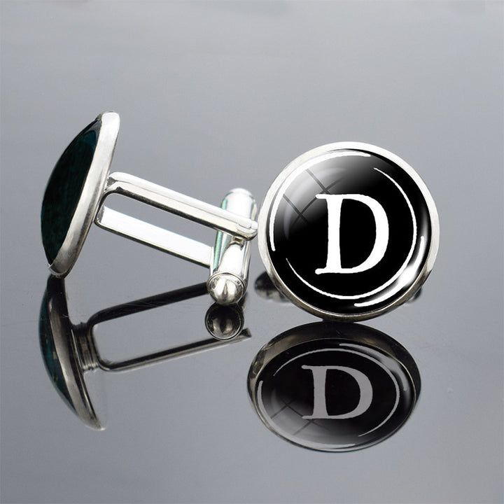Cufflinks with a black round design featuring the letter &