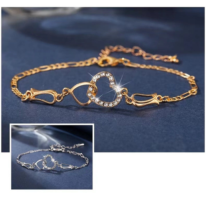 Gold bracelet with heart and infinity symbol on a blue background