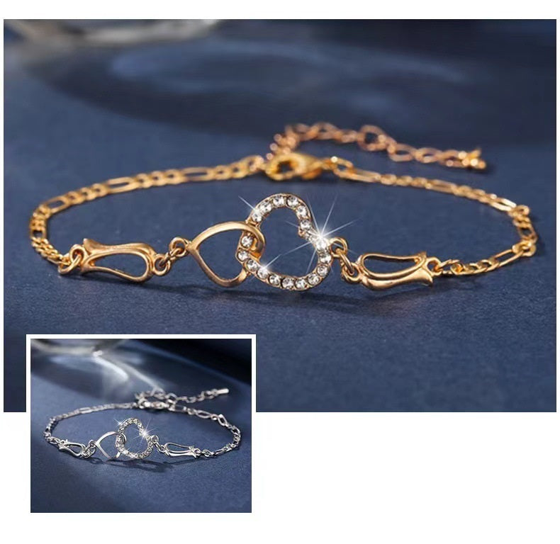 Gold bracelet with heart and infinity symbol on a blue background