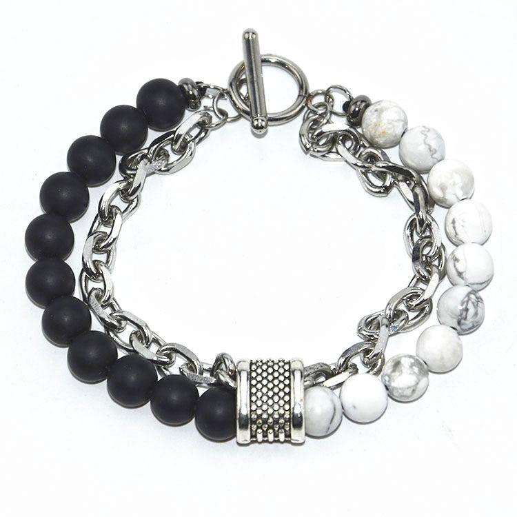 Bracelet with black beads, white beads, and silver chain on a white background