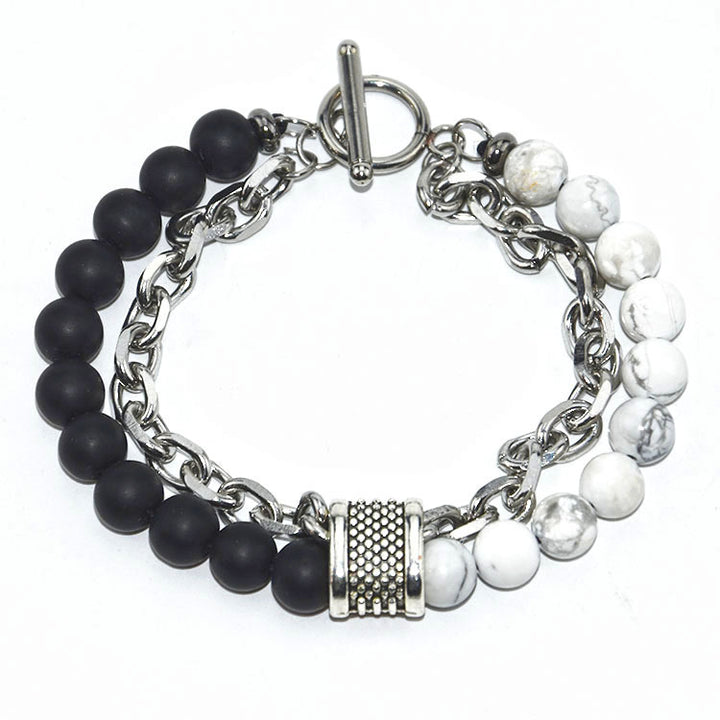 Bracelet with black beads, white beads, and silver chain on a white background