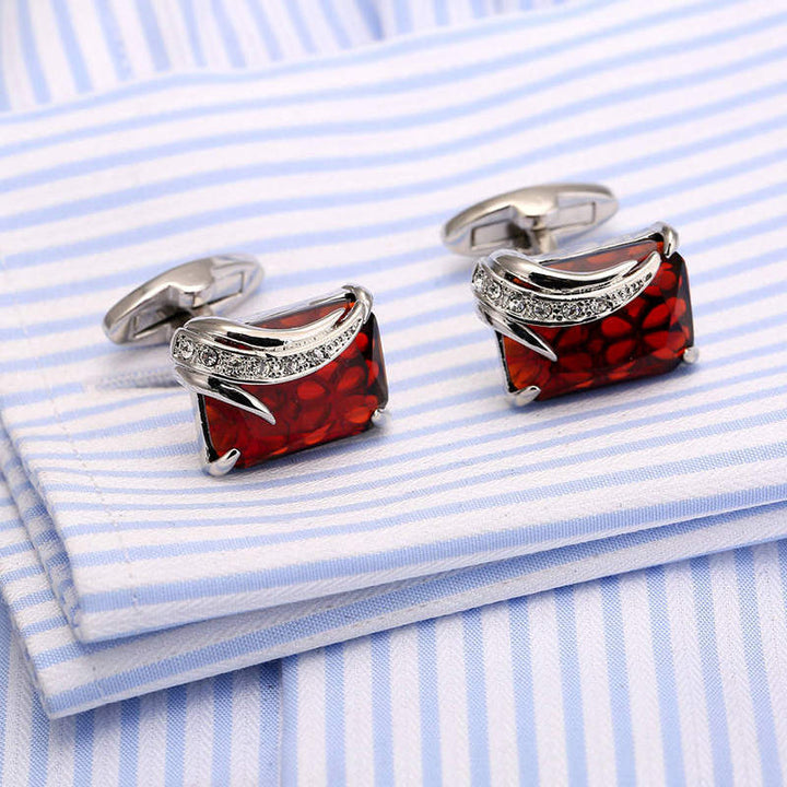 Red and silver cufflinks on a blue and white striped shirt