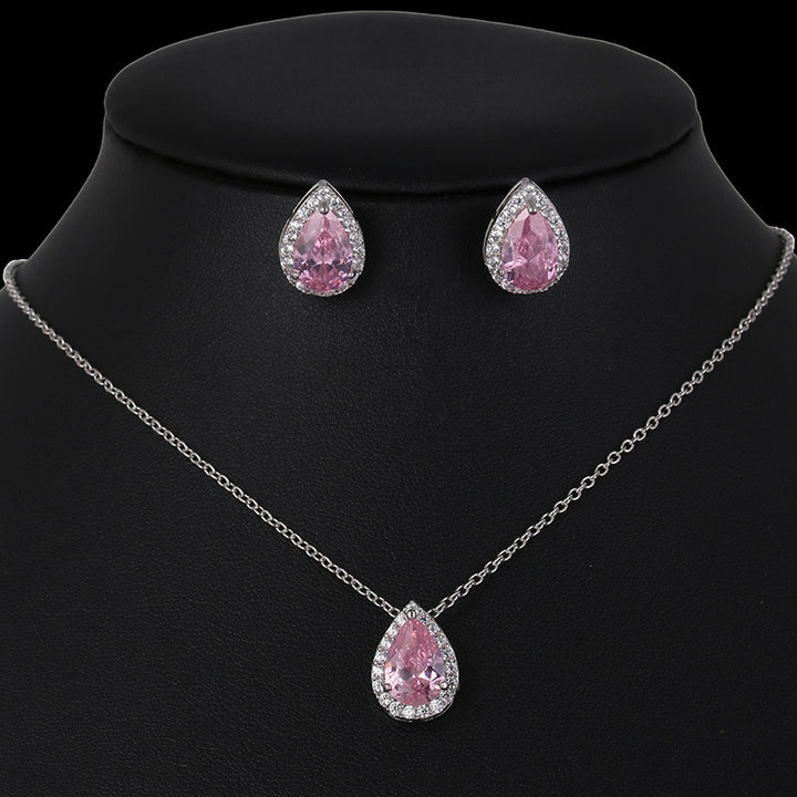 Jewelry set with pink teardrop-shaped gemstones on a black background