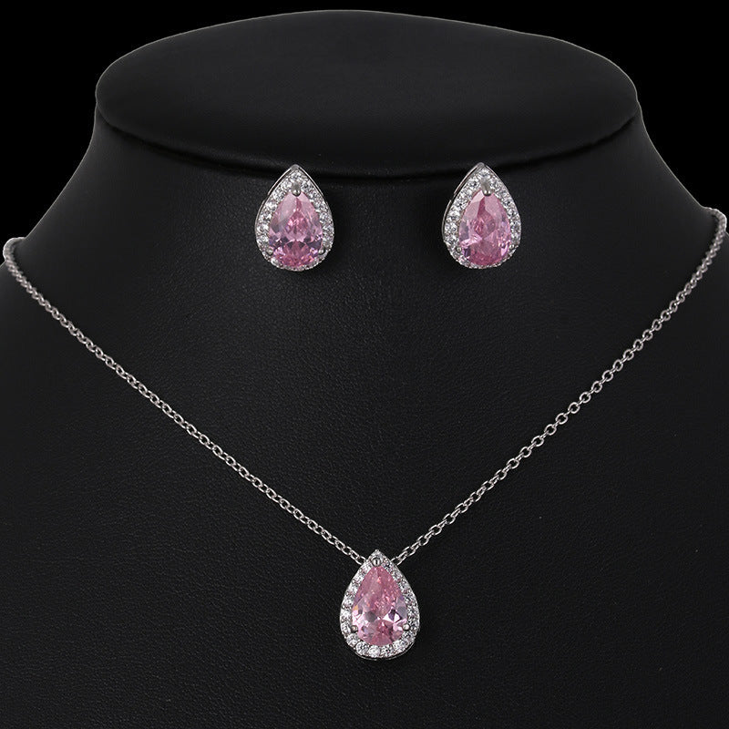 Jewelry set with pink teardrop-shaped gemstones on a black background