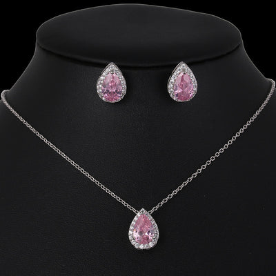 Jewelry set with pink teardrop-shaped gemstones on a black background