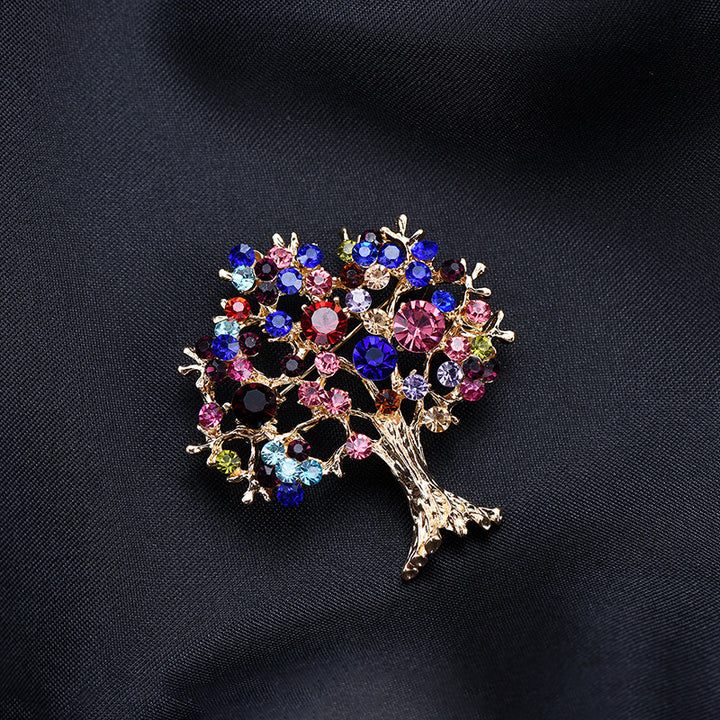 Decorative tree brooch with multicolored gemstones on a black background