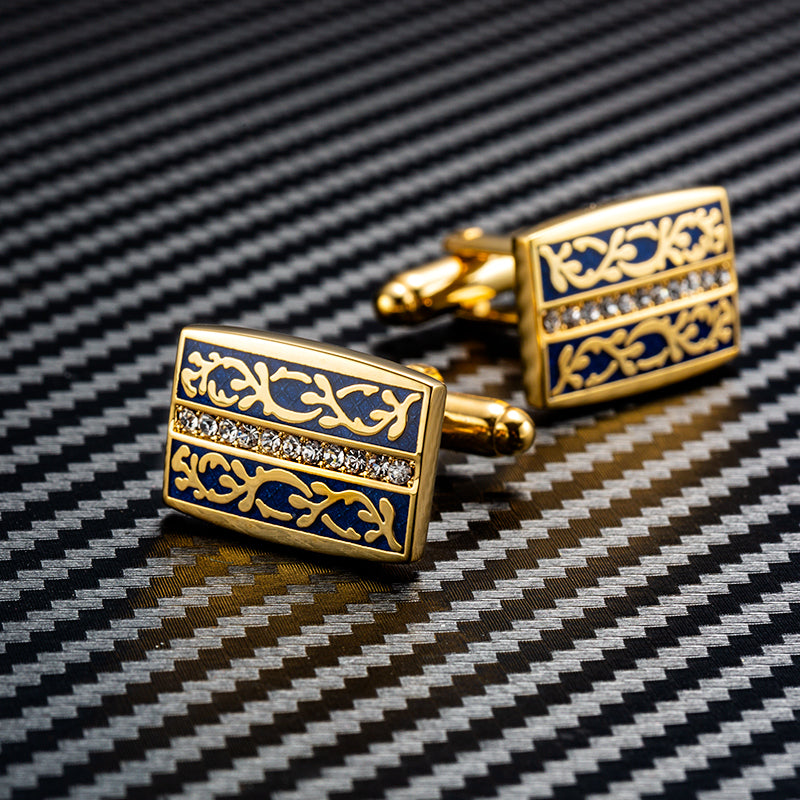 Gold and blue cufflinks on a black and white background