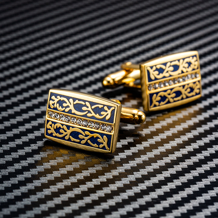 Gold and blue cufflinks on a black and white background