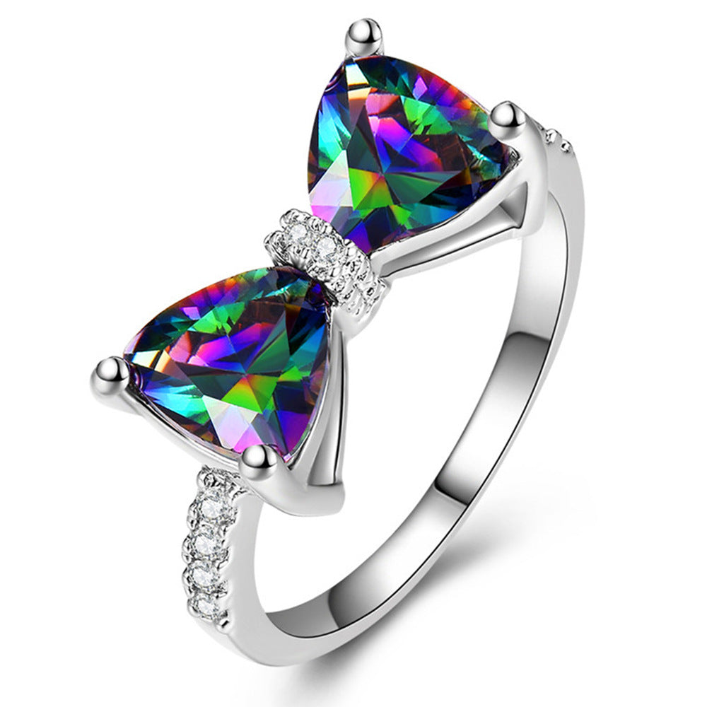Silver ring with two rainbow-colored gemstones on a white background
