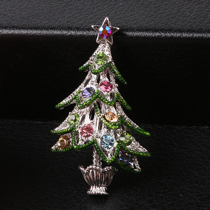 Decorative Christmas tree brooch with colorful gemstones on a black background