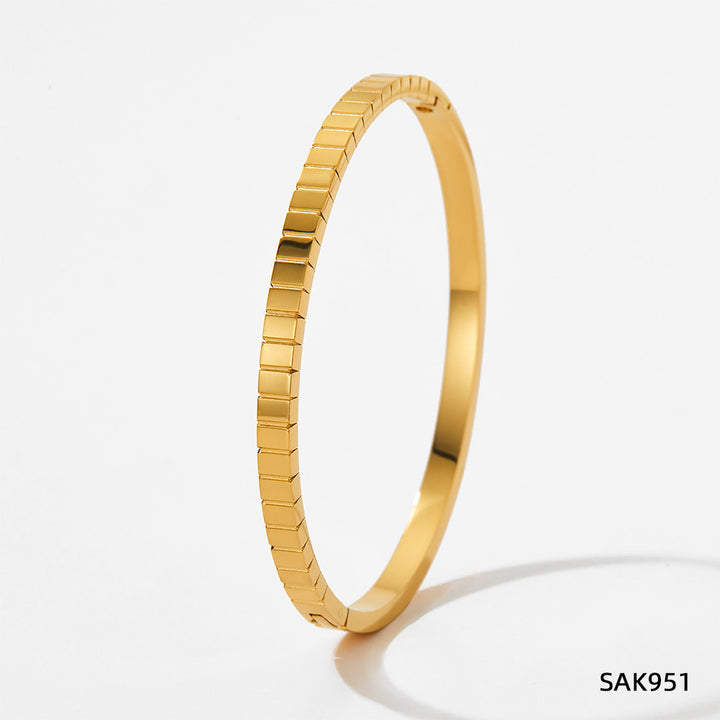 Gold bracelet on a light gray background