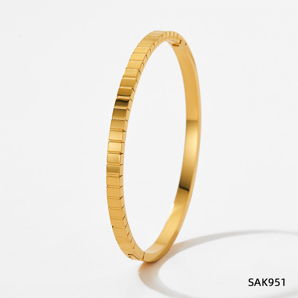 Gold bracelet on a light gray background