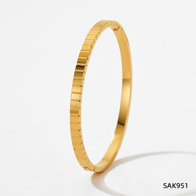 Gold bracelet on a light gray background