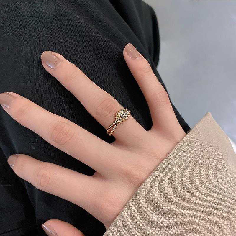 Hand wearing a gold ring with a black background