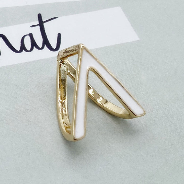 Gold ring with a white stone on a light gray background