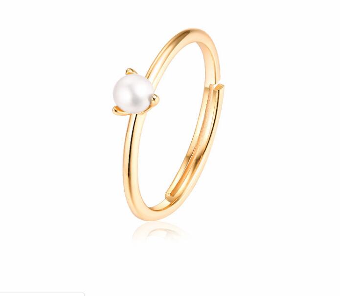 Gold ring with a pearl on a white background
