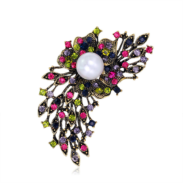 Decorative brooch with colorful gemstones and a pearl on a white background