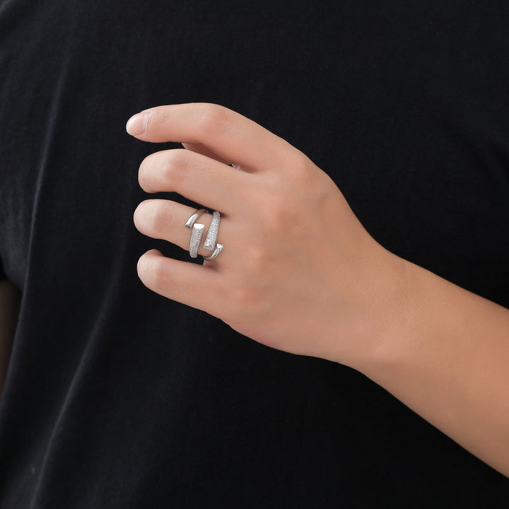Hand wearing a silver ring on a black background