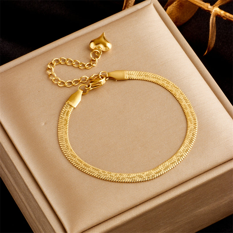 Gold bracelet on a beige jewelry box with a dark background