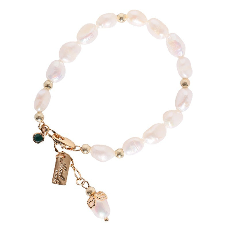 Pearl bracelet with gold charms on a white background