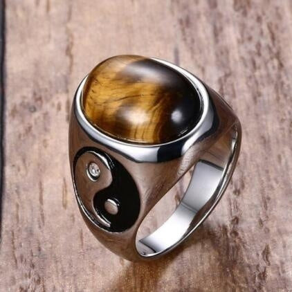 Silver ring with a tiger's eye stone on a wooden background