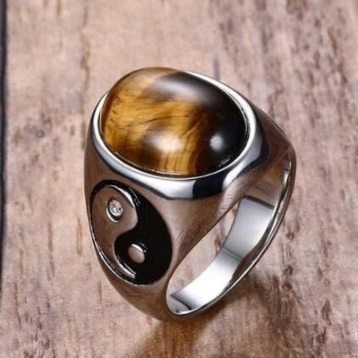 Silver ring with a tiger's eye stone on a wooden background