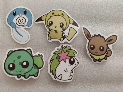 Five cartoon character stickers on a metallic surface