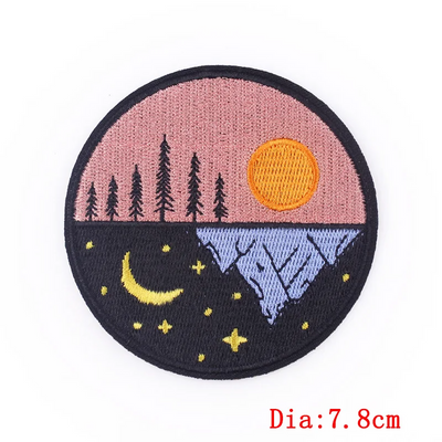 Round embroidered patch with day and night landscape design on a white background