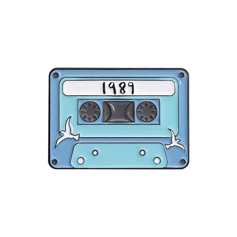 Cassette tape-shaped enamel pin with '1989' on a white background