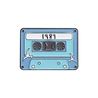 Cassette tape-shaped enamel pin with '1989' on a white background