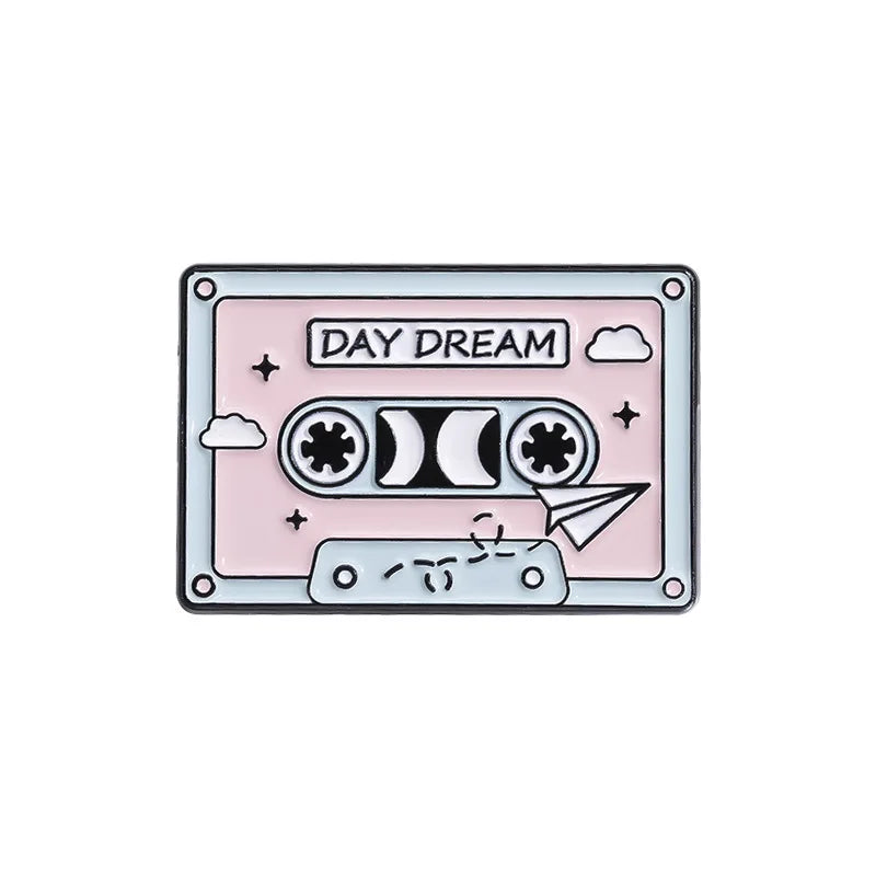 Cassette tape design enamel pin with 'Day Dream' text on a light pink background