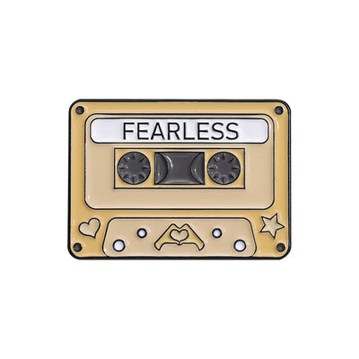 Cassette tape-shaped enamel pin  with 'FEARLESS' text on a white background