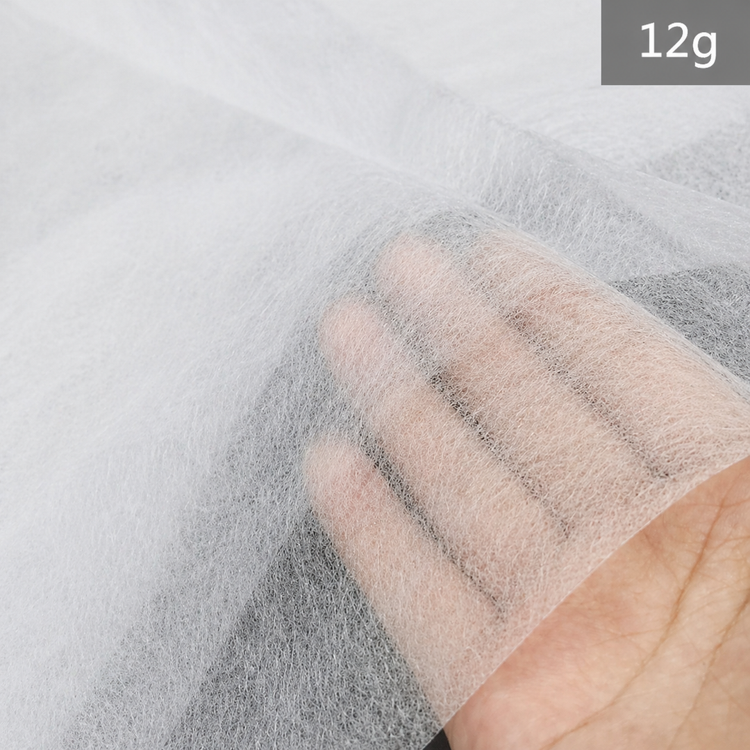 Hand holding a white Fusible Interlining Fabric with &