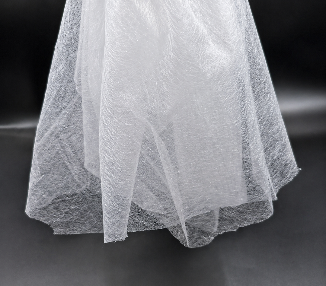 Close-up of a white Fusible Interlining Fabric with a textured pattern on a dark background