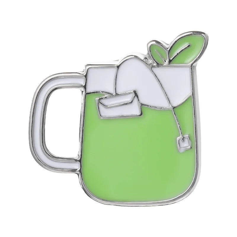 Enamel pin of a Green mug with a white handle and a small white flag on a white background