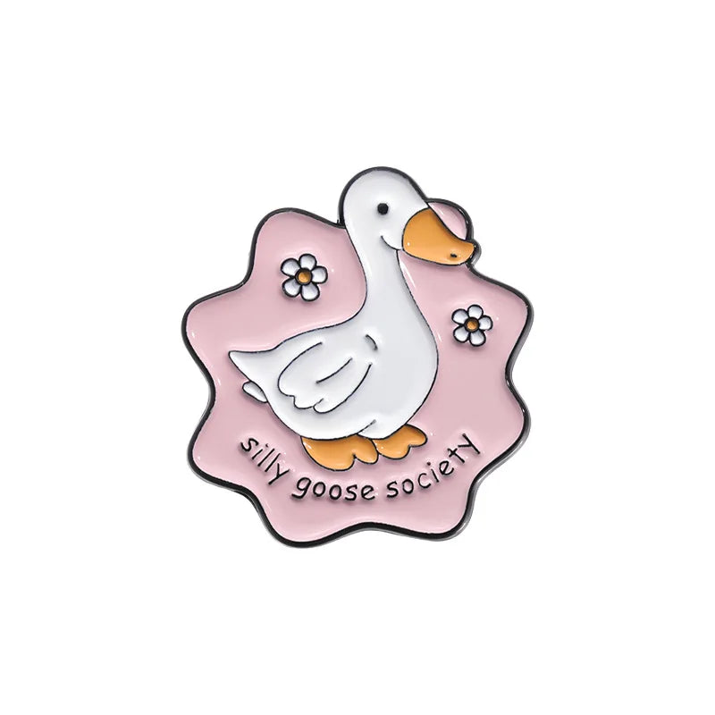 Enamel pin with a goose design and 'silly goose society' text on a pink background
