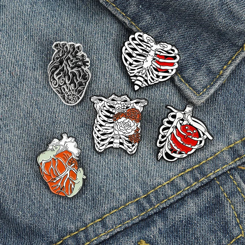 Five anatomical-themed pins on a denim jacket