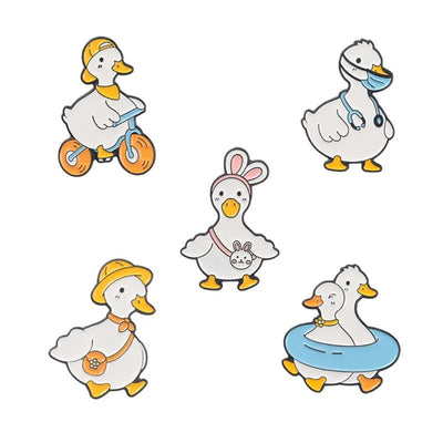 enamel pins of Five cartoon ducks in various poses on a white background