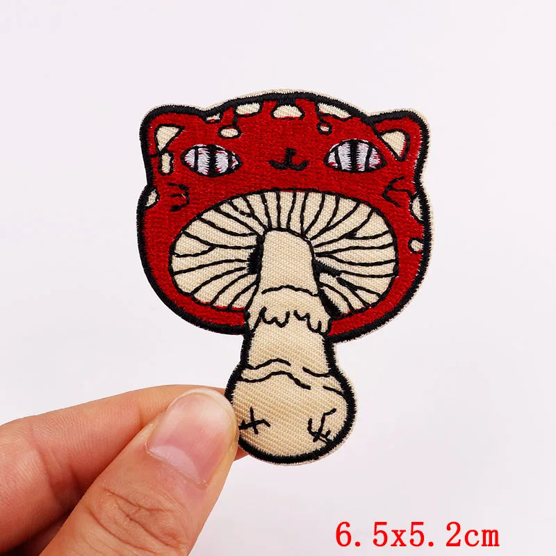 Mushroom-shaped patch with cat ears held by a hand on a white background
