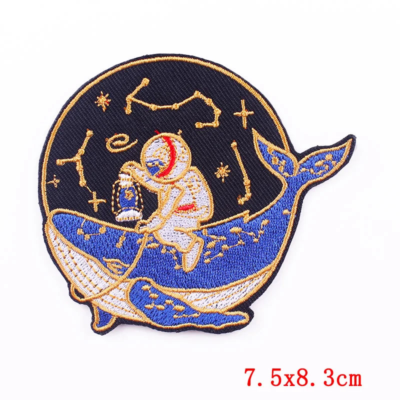 Embroidered patch with an astronaut on a whale, stars, and constellations on a dark blue background.