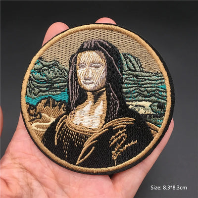 Embroidered patch of Mona Lisa held in a hand with a dark background