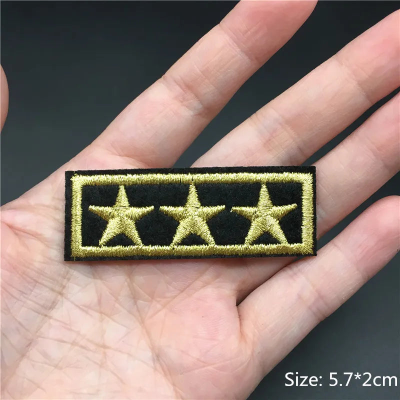 Five-star patch held in a hand with a dark background