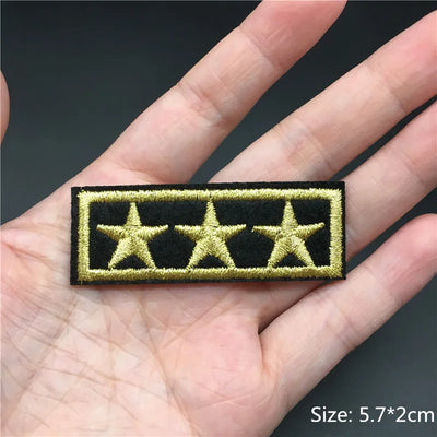 Five-star patch held in a hand with a dark background