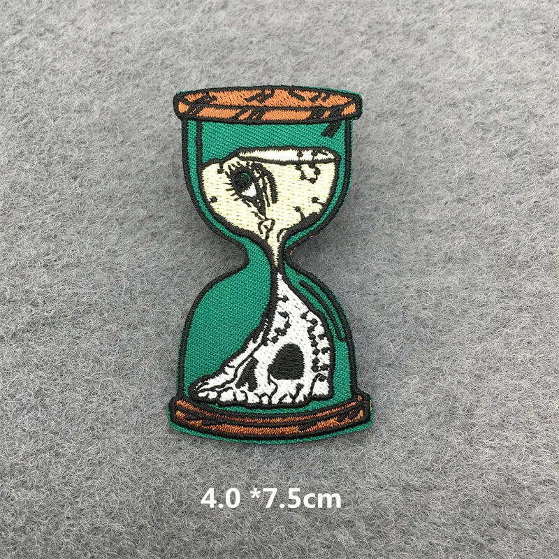 Hourglass design patch with skeleton face on a gray background
