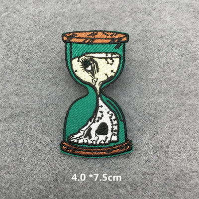 Hourglass design patch with skeleton face on a gray background