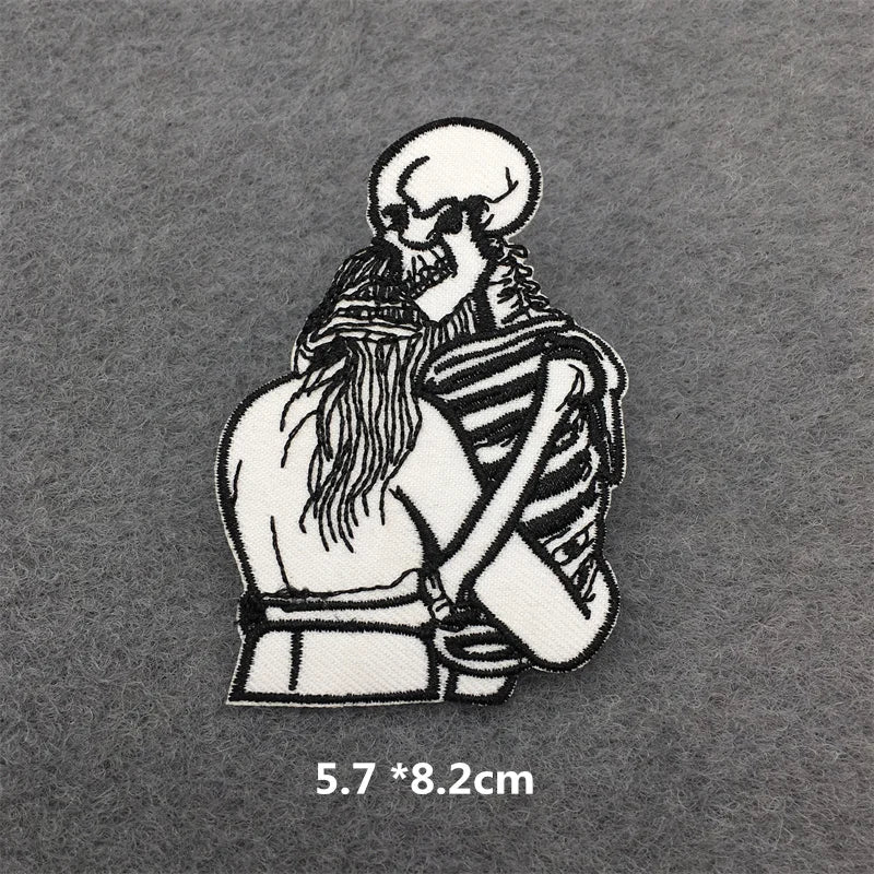 Embroidered patch of a skeleton hugging a person on a gray background