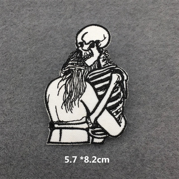 Embroidered patch of a skeleton hugging a person on a gray background