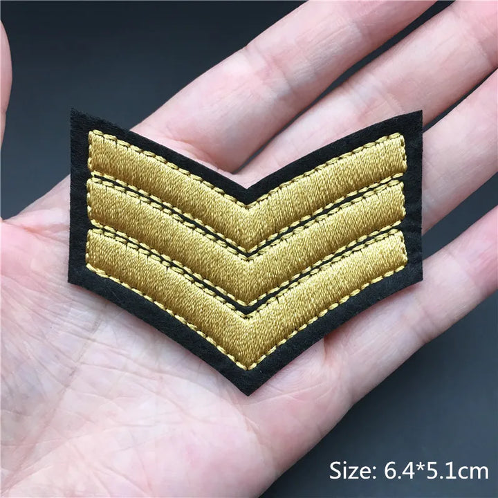 Gold military rank patch on a hand with size label